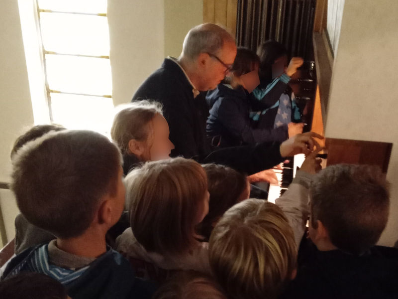 Thorsten Steinhoff mit Grundschulkindern (unkenntlich gemacht) an der Orgel von St. Anna Berlin Baumschulenweg
